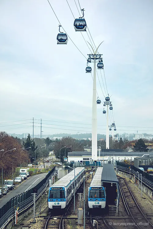 Urbane Seilbahn Cable 1 mit Stützen und Omega V Kabinen von Doppelmayr über einer Bahnstation in Ile-de-France, Paris