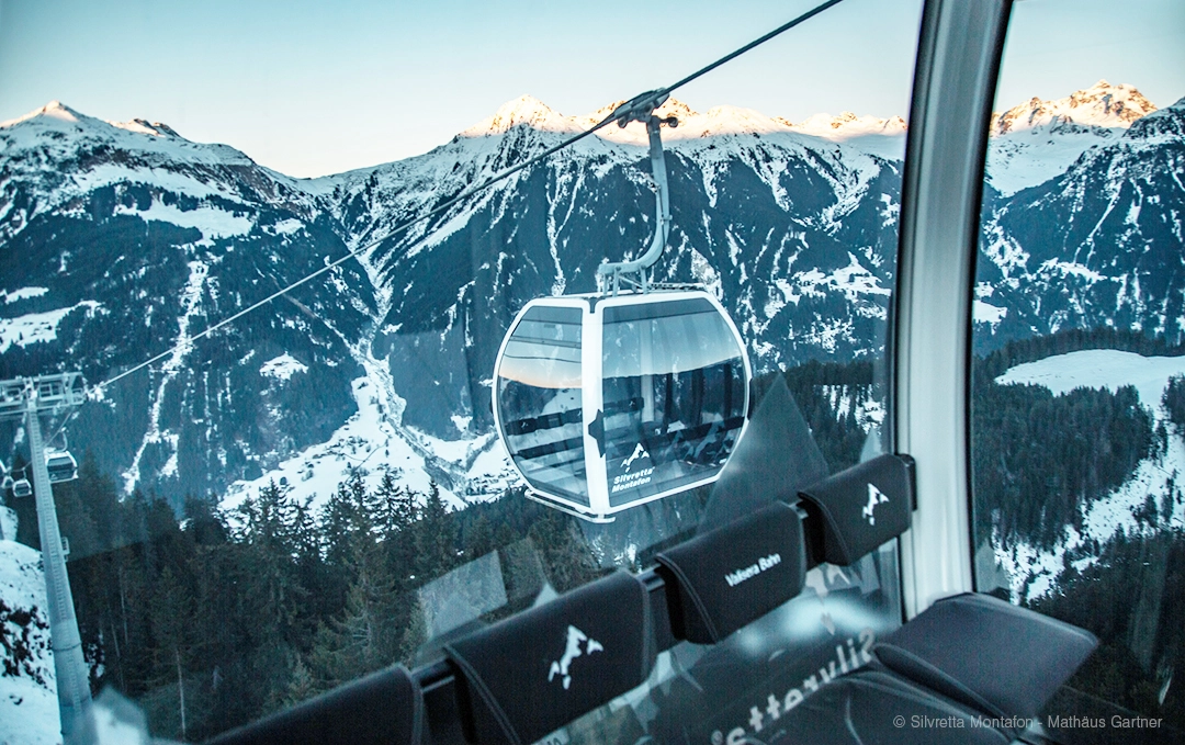 Omega V Kabine der Seilbahn Valisera Bahn mit Kabinengrafiken vor Bergpanorama mit Schnee und Sonnenschein in Österreich
